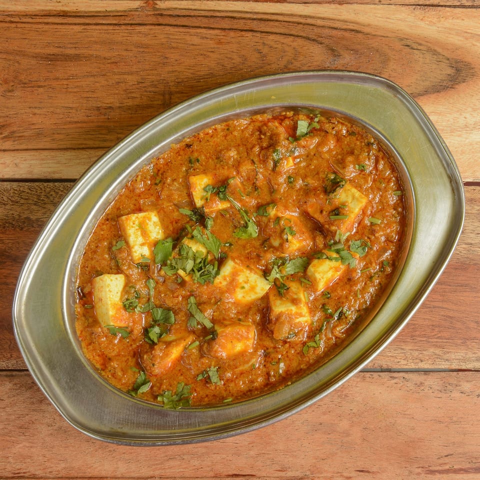 Tikka House Express's Paneer Butter Masala, a rich Indian curry with paneer cubes and fresh cilantro.